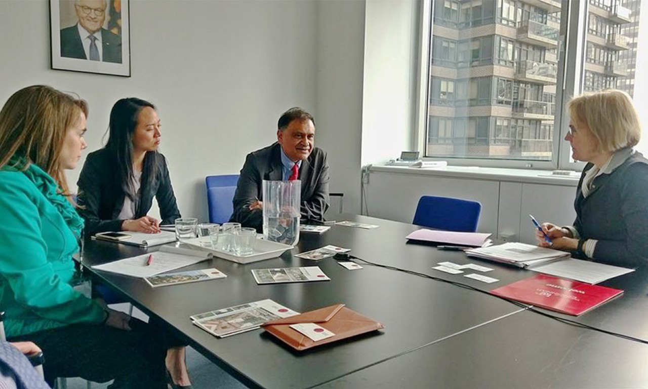 People converse around a conference table.